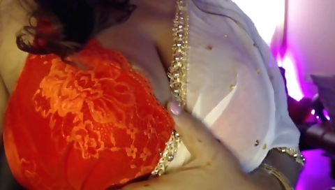 Sexy brunette with big tits enjoys nipple play on a bed