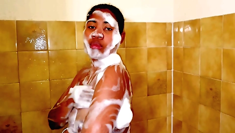 Slender ebony teen takes a hot shower and undresses