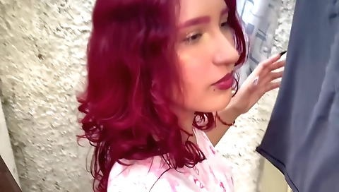 Red head girl with a hot skirt is playing with the grass